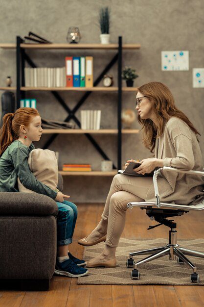 professional-help-professional-female-psychologist-holding-her-notebook-while-listening-her-young-patient_259150-44187